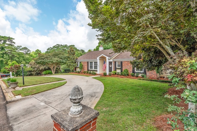 702 W Lee St, Enterprise, AL 36330 - ranch-style home with brick siding, curved driveway, a front yard, and a chimney