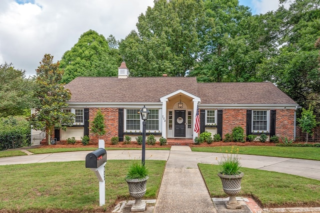 702 W Lee St, Enterprise, AL 36330 - ranch-style home featuring brick siding, a front lawn, a shingled roof, and curved driveway
