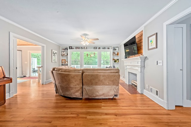 702 W Lee St, Enterprise, AL 36330 - living area featuring crown molding, ceiling fan, light wood finished floors, a fireplace with flush hearth, and built in features