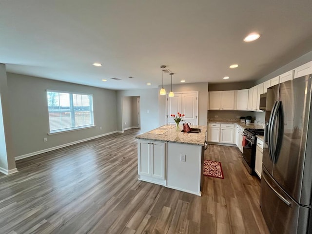 kitchen featuring a kitchen island, appliances with stainless steel finishes, decorative light fixtures, white cabinetry, and light stone counters