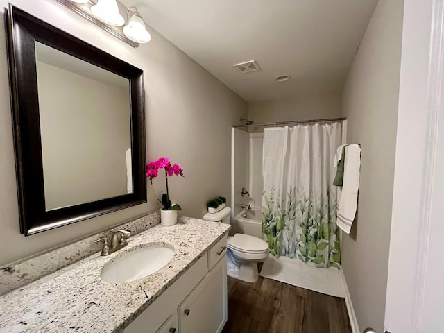 full bathroom with vanity, hardwood / wood-style floors, toilet, and shower / bath combo with shower curtain