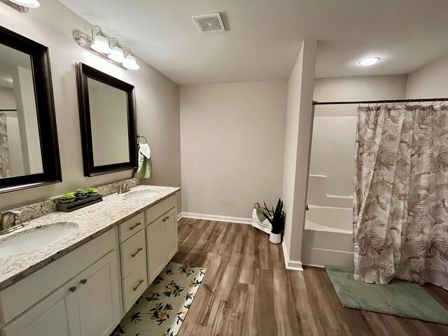 bathroom featuring hardwood / wood-style flooring, vanity, and shower / tub combo with curtain