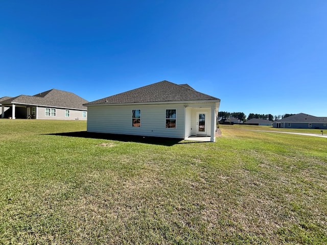 rear view of property featuring a lawn