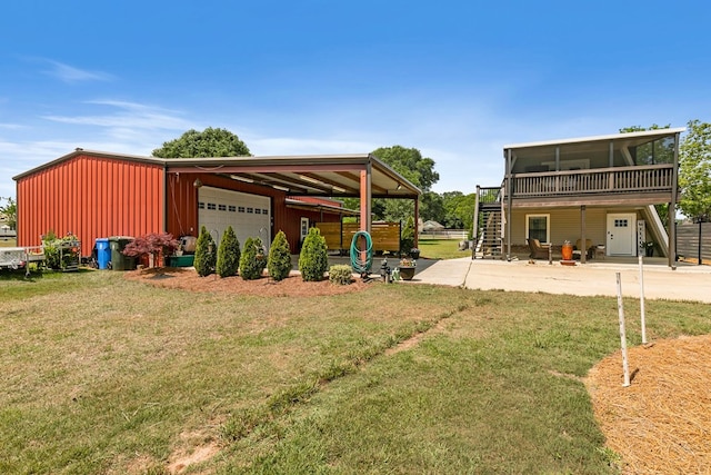 exterior space featuring an outdoor structure, a garage, stairs, a sunroom, and a yard