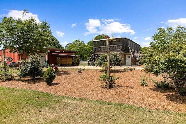 view of yard featuring a sunroom, an outdoor structure, and stairway