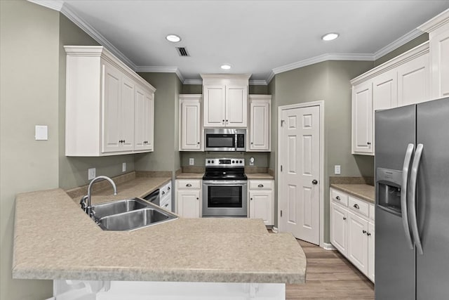133 Brockton Ct, Dothan, AL 36305 - kitchen featuring stainless steel appliances, a peninsula, light wood finished floors, recessed lighting, and crown molding