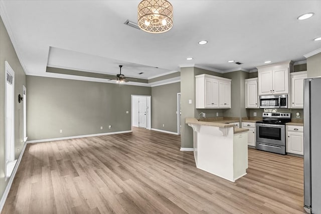 133 Brockton Ct, Dothan, AL 36305 - kitchen featuring appliances with stainless steel finishes, recessed lighting, a peninsula, white cabinetry, and light wood-style floors