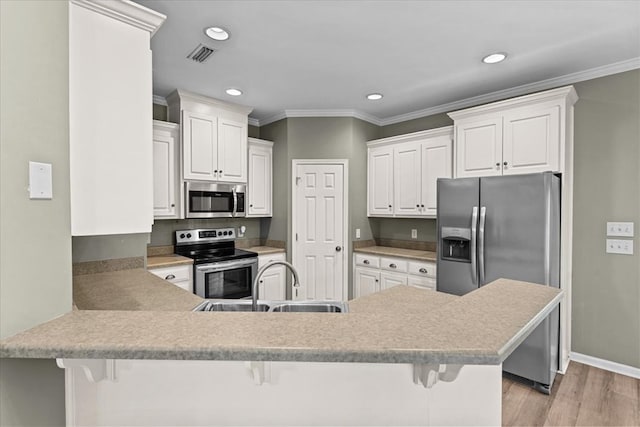 133 Brockton Ct, Dothan, AL 36305 - kitchen with appliances with stainless steel finishes, a peninsula, light wood-style floors, crown molding, and a kitchen bar