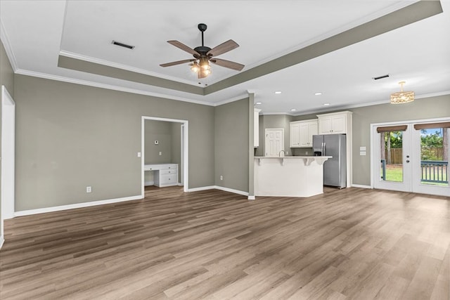 133 Brockton Ct, Dothan, AL 36305 - unfurnished living room with a tray ceiling, wood finished floors, ceiling fan, ornamental molding, and recessed lighting