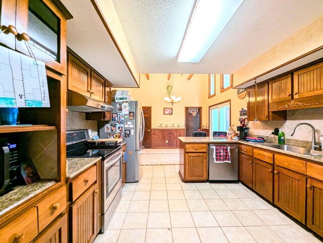 kitchen with a textured ceiling, stainless steel appliances, sink, light tile patterned floors, and an inviting chandelier