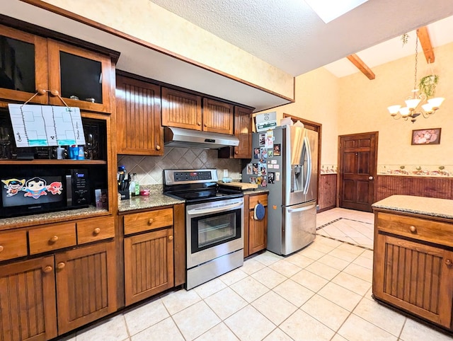 kitchen featuring light stone countertops, a chandelier, a textured ceiling, light tile patterned floors, and appliances with stainless steel finishes