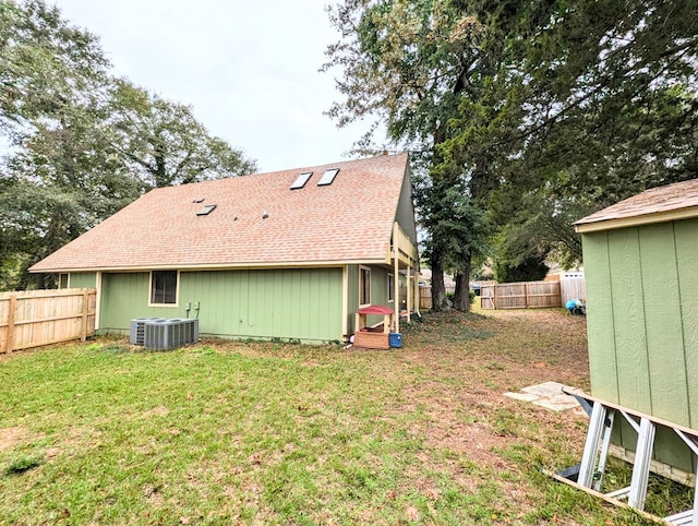 rear view of property with a lawn and cooling unit