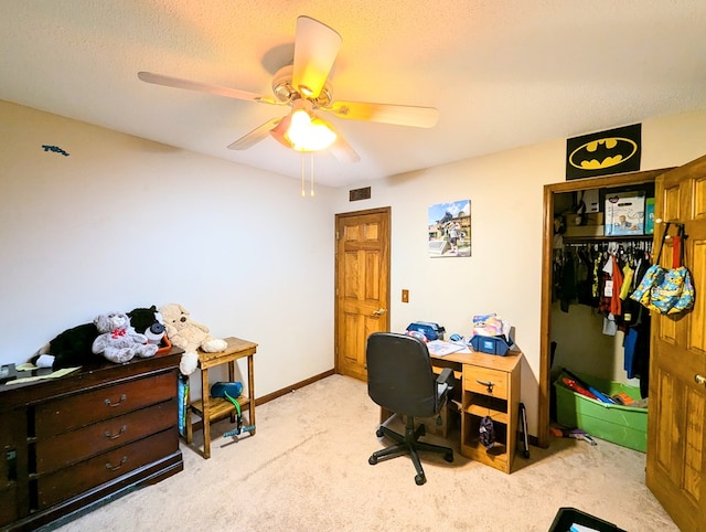 carpeted office space with a textured ceiling and ceiling fan