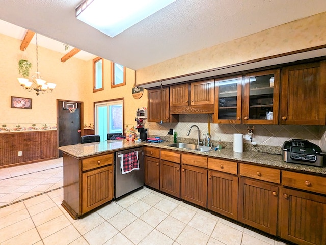 kitchen featuring kitchen peninsula, stainless steel dishwasher, dark stone counters, sink, and a notable chandelier