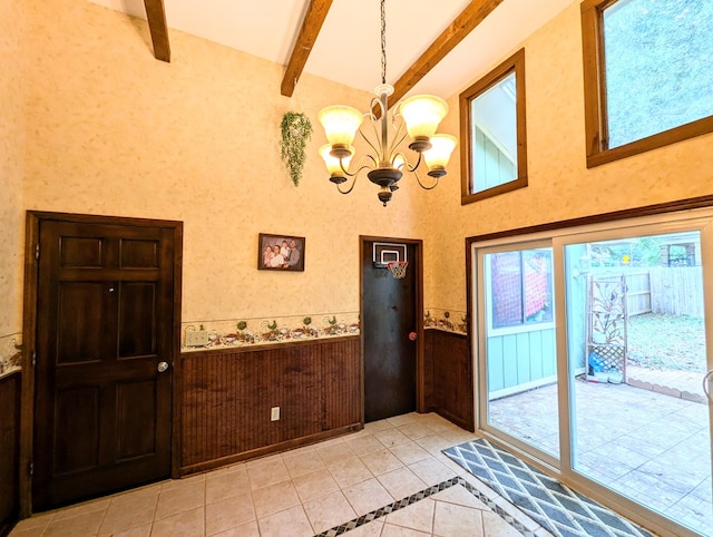 entryway with beam ceiling, light tile patterned floors, wooden walls, and a chandelier