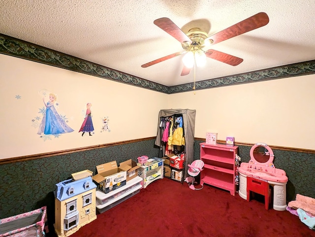 rec room with ceiling fan, carpet floors, and a textured ceiling