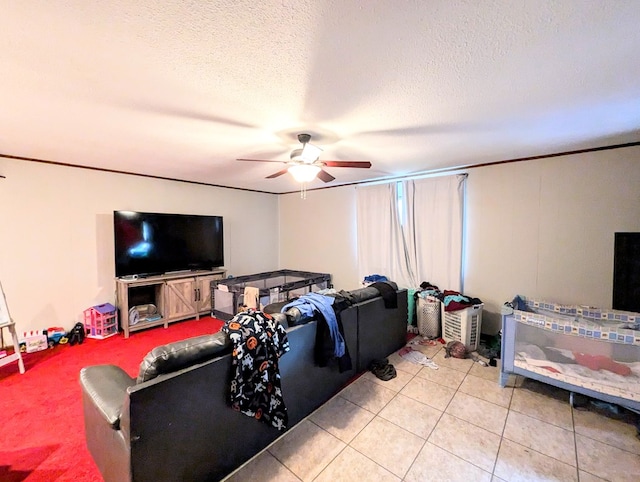 living room with ceiling fan, light tile patterned flooring, and a textured ceiling