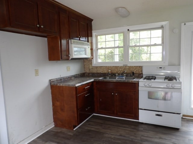 kitchen with dark hardwood / wood-style flooring, sink, and white appliances