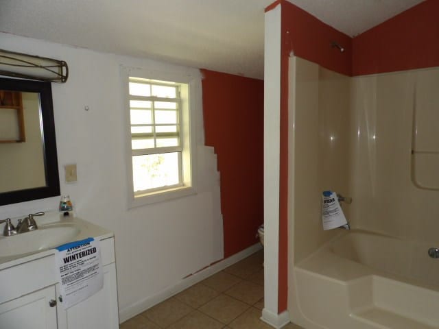 full bathroom featuring toilet, vanity, bathing tub / shower combination, and tile patterned floors