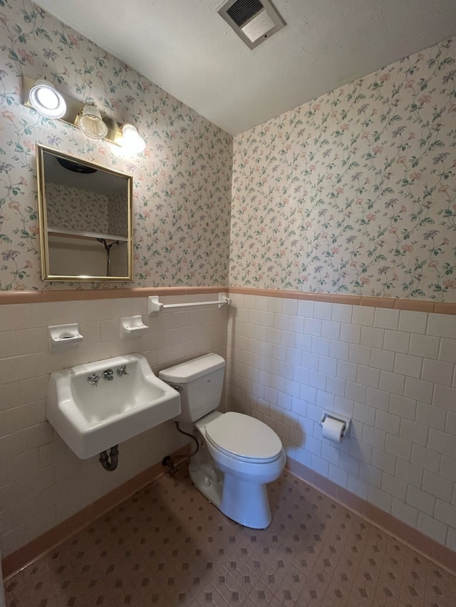 1000 Martin St, Dothan, AL 36301 - half bath with wallpapered walls, a sink, and a wainscoted wall