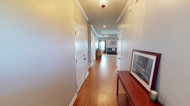 corridor with hardwood / wood-style floors and ornamental molding