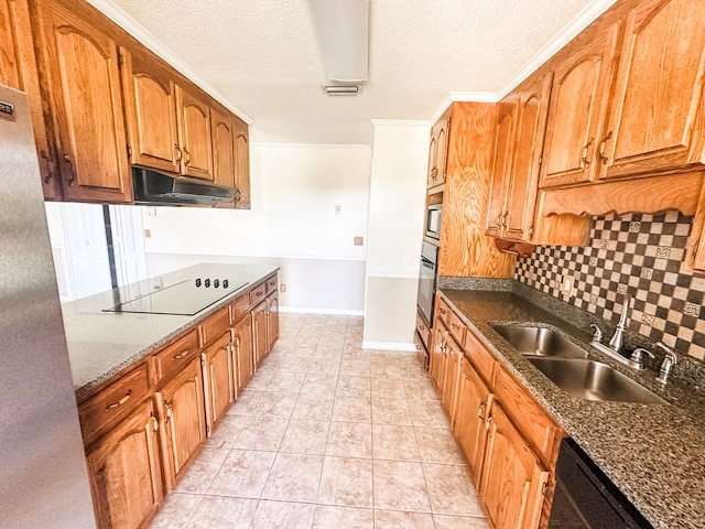 kitchen with tasteful backsplash, visible vents, black appliances, under cabinet range hood, and a sink
