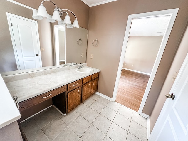 bathroom with ornamental molding, tile patterned flooring, baseboards, and vanity