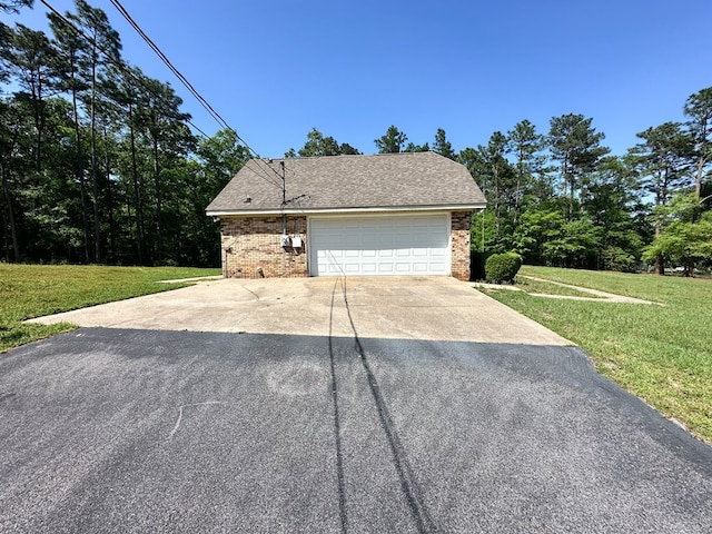 view of property exterior with a yard, brick siding, and driveway