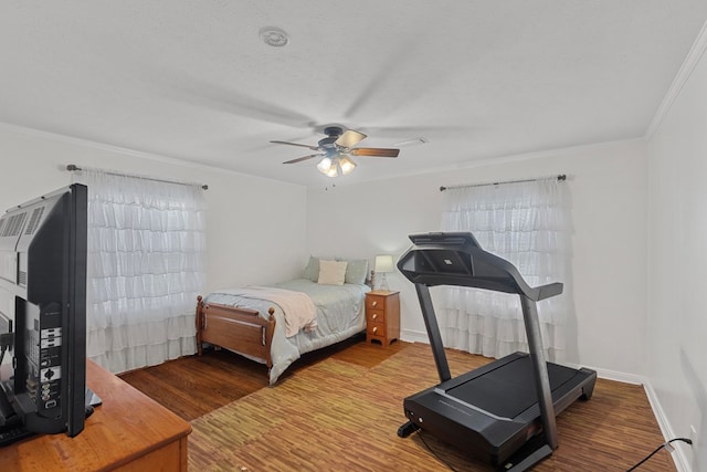 bedroom featuring ceiling fan, crown molding, wood-type flooring, and a textured ceiling