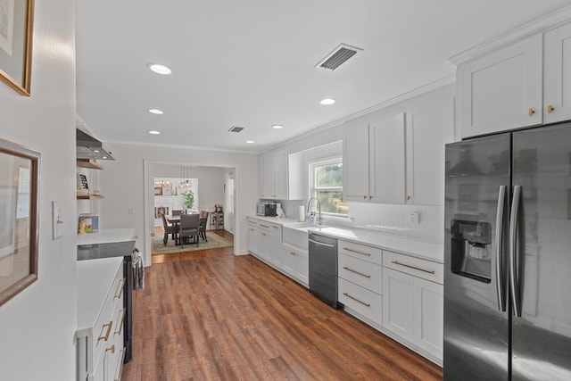 kitchen with appliances with stainless steel finishes, sink, white cabinetry, dark hardwood / wood-style floors, and crown molding