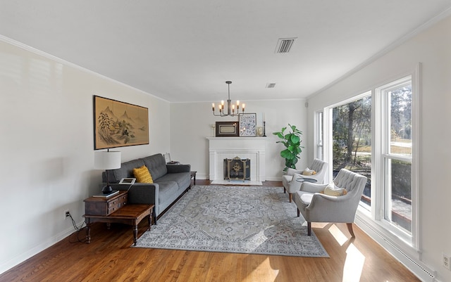 living room with ornamental molding, hardwood / wood-style floors, and a notable chandelier