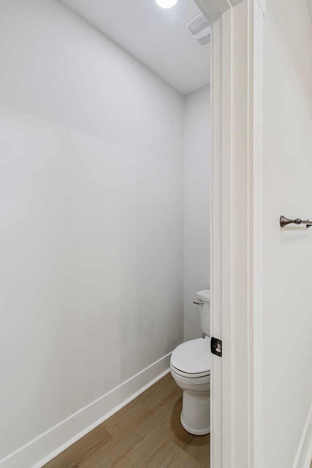 bathroom with hardwood / wood-style floors and toilet