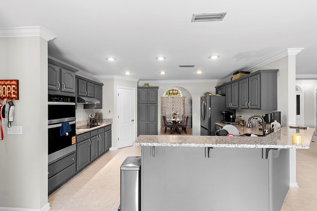 6 Piedmont Pl, Enterprise, AL 36330 - kitchen featuring appliances with stainless steel finishes, a peninsula, light tile patterned flooring, a breakfast bar, and gray cabinetry