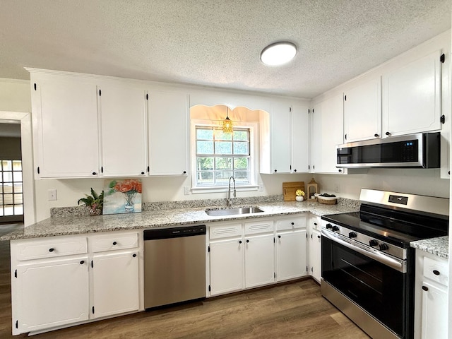143 Durby Ln, Dothan, AL 36305 - kitchen featuring appliances with stainless steel finishes, a textured ceiling, dark wood finished floors, white cabinetry, and light stone counters