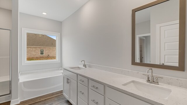 330 Heritage Way, Headland, AL 36345 - full bathroom with double vanity, a sink, a bath, and wood finished floors
