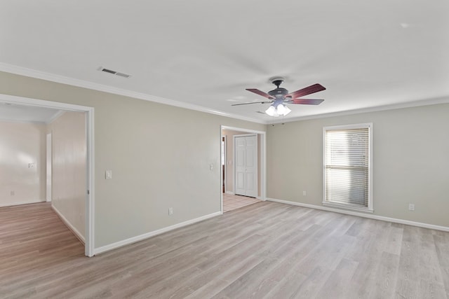 spare room featuring crown molding, a ceiling fan, visible vents, and light wood-style floors