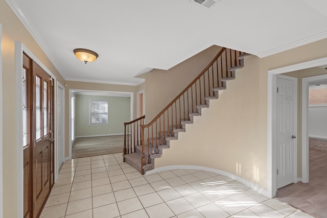 foyer entrance featuring visible vents, ornamental molding, stairs, and light tile patterned floors
