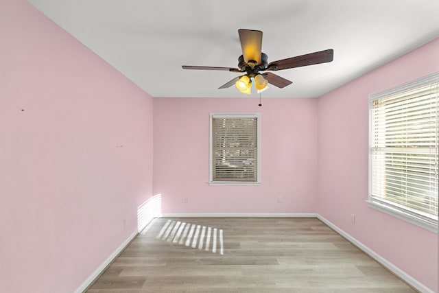spare room with light wood-style floors, baseboards, and a ceiling fan