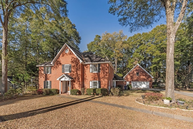 colonial inspired home featuring brick siding, a garage, and driveway