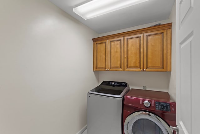laundry area featuring baseboards, independent washer and dryer, and cabinet space
