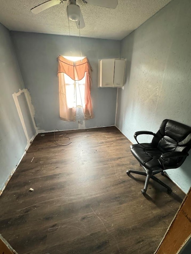 unfurnished dining area with ceiling fan, a textured ceiling, and hardwood / wood-style flooring