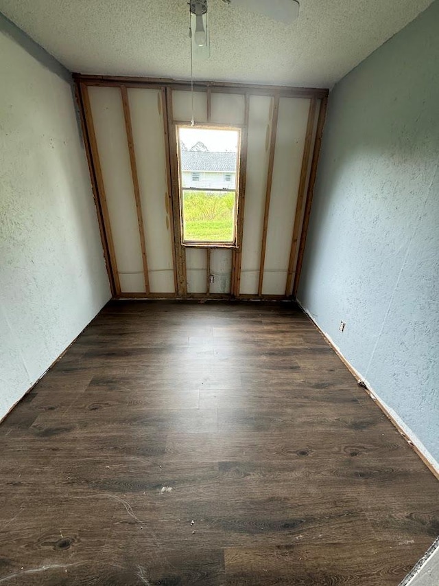 empty room featuring a textured ceiling and dark wood-type flooring