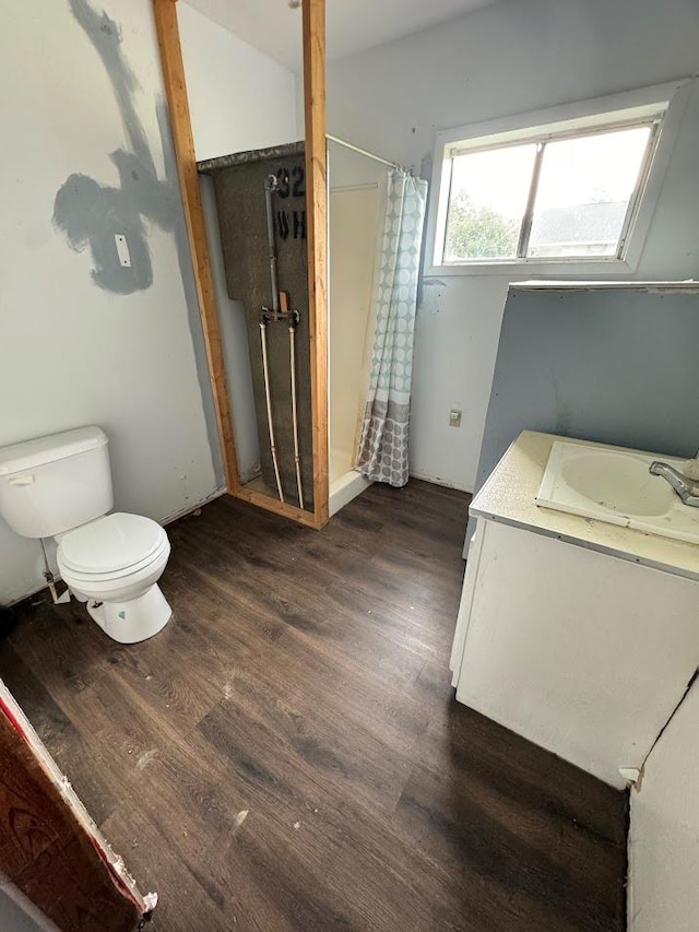 bathroom featuring curtained shower, toilet, vanity, and hardwood / wood-style flooring