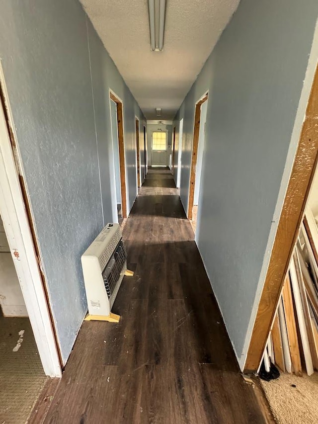 hallway featuring dark wood-type flooring and heating unit