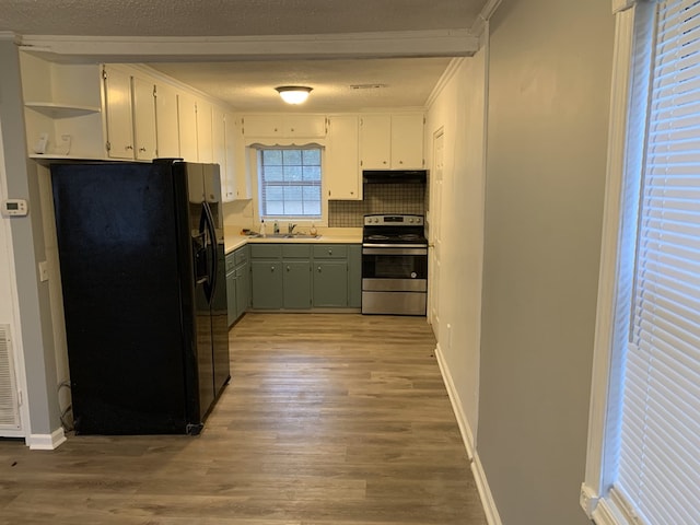 kitchen with black refrigerator with ice dispenser, light wood-style flooring, stainless steel range with electric cooktop, a sink, and a textured ceiling