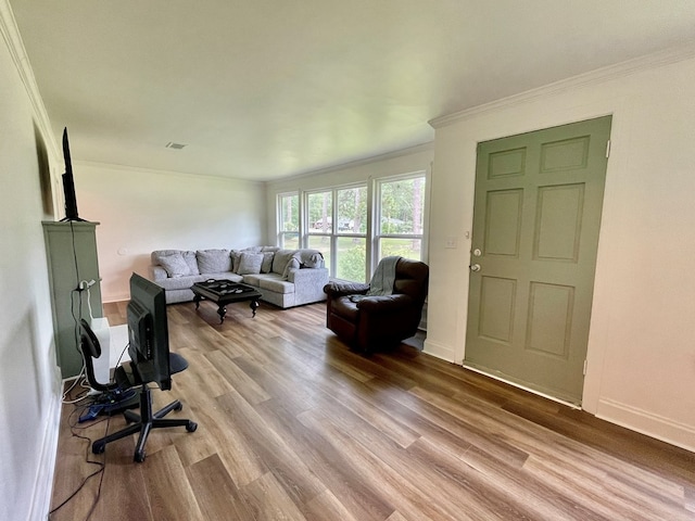 living room featuring light hardwood / wood-style flooring and crown molding