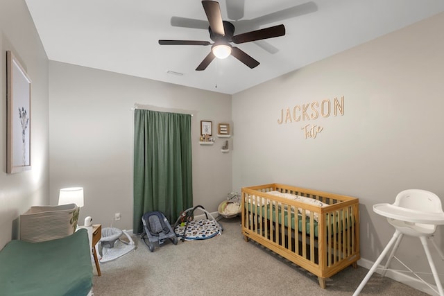 bedroom with carpet flooring, a nursery area, and ceiling fan