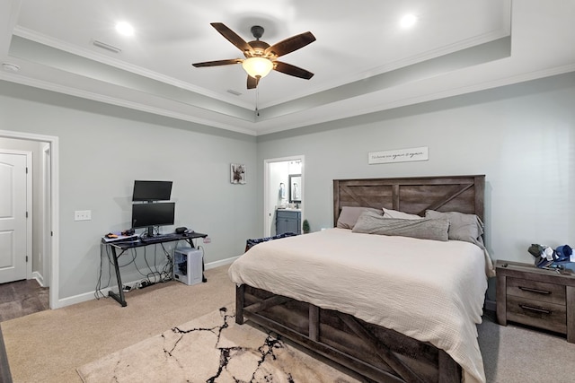 bedroom featuring ensuite bath, ceiling fan, a raised ceiling, crown molding, and carpet