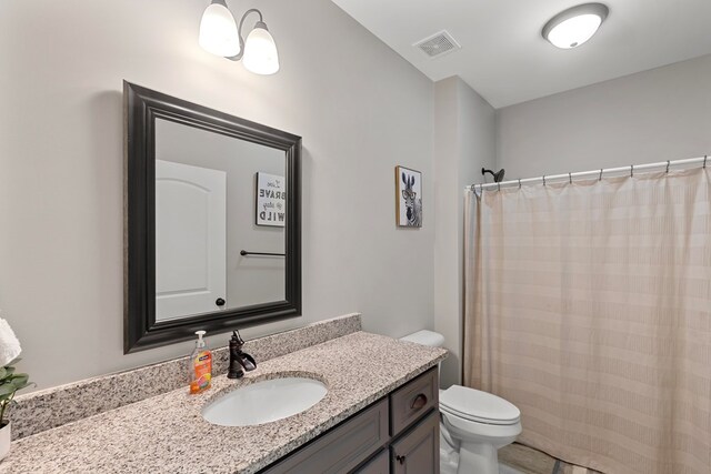 bathroom featuring curtained shower, vanity, and toilet