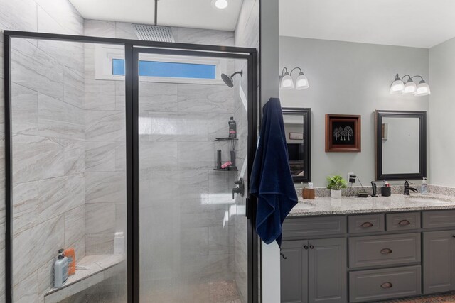 bathroom with vanity and a shower with door